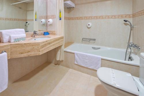 y baño con bañera, aseo y lavamanos. en Hotel Montemar Maritim, en Santa Susanna