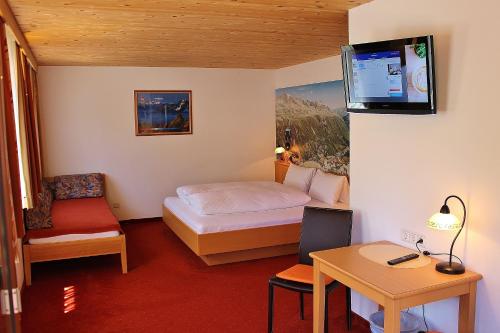 Habitación de hotel con cama y TV en la pared en Haus Gisela en Oetz