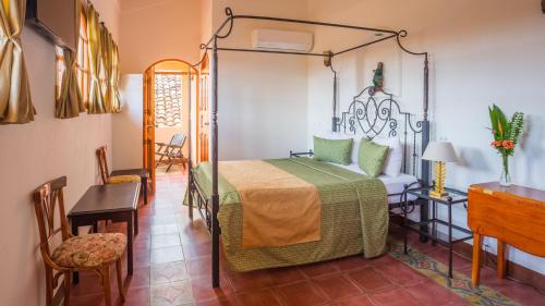 - une chambre avec un lit, une table et des chaises dans l'établissement Hotel Casa San Francisco, à Granada