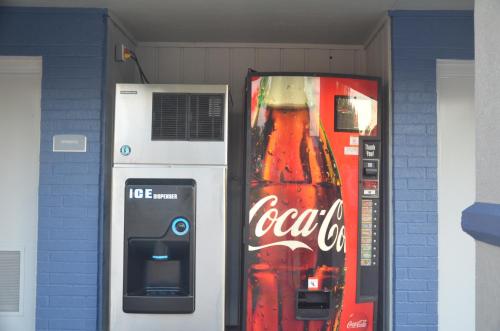 a coke machine next to a cocacola vending machine at Travelers Inn in Rosenberg