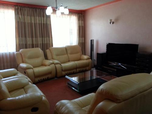 a living room with two couches and a television at Chester View Homestay in Syokimau