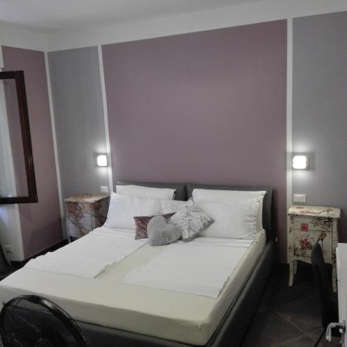 a bedroom with a bed with white sheets and pillows at Casa Donatella in Malcesine