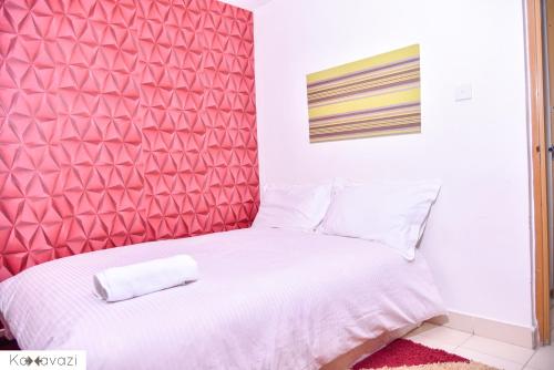 a bedroom with a red headboard and a white bed at Outlink Skyline Minutes to JKIA airport in Nairobi