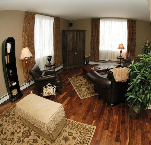 a living room with leather furniture and wood floors at Spanish Bay Inn, CANADA in Sydney
