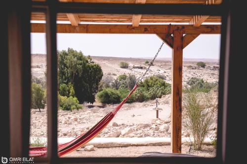 a hammock in a room with a view of the desert at Hamitzpa- Desert Hosting in Ezuz in ‘Ezuz