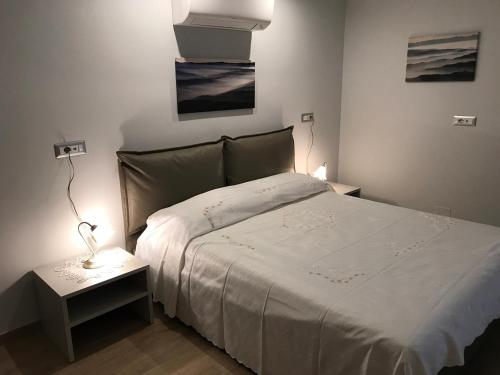 1 dormitorio con 1 cama y 1 mesa con lámpara en Casa Soave B&B, en Alba