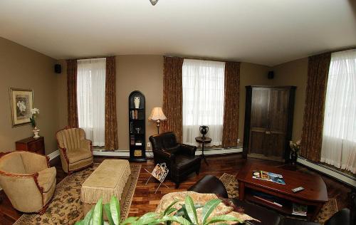 a living room filled with furniture and windows at Spanish Bay Inn, CANADA in Sydney