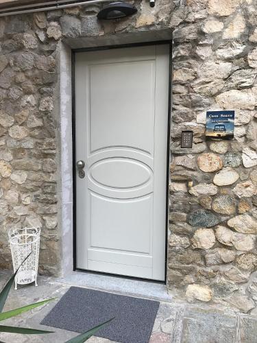 a white door in a stone wall with a basketball hoop at Casa Soave B&B in Alba