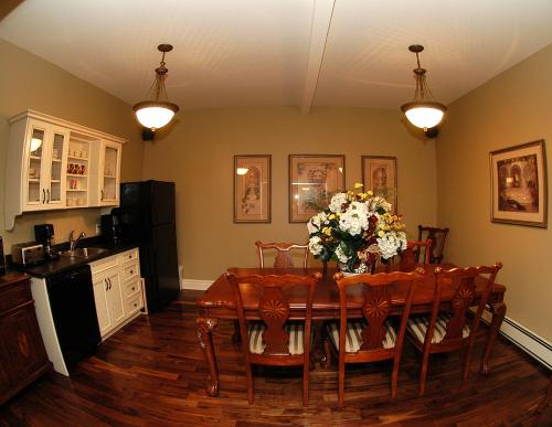 a dining room with a table with flowers on it at Spanish Bay Inn, CANADA in Sydney
