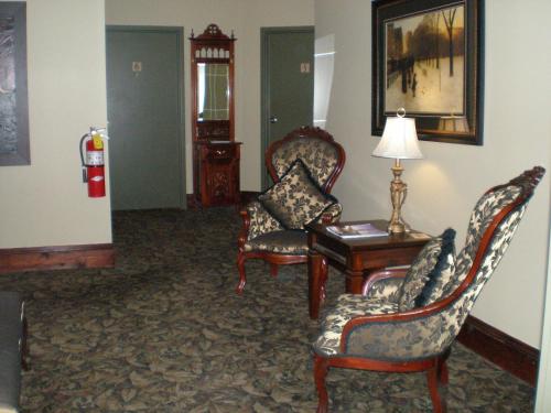 a living room with chairs and a table and a lamp at Spanish Bay Inn, CANADA in Sydney