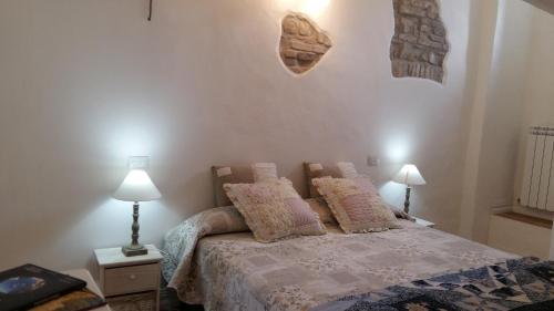 um quarto com uma cama com almofadas e 2 candeeiros em Ai Barutoli em Perugia