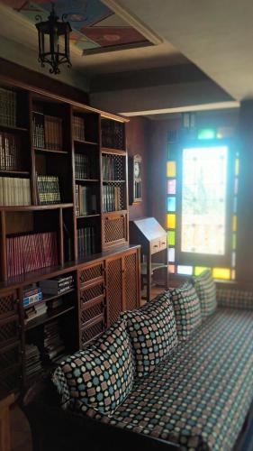 a living room with a couch in a library at Villa du Souss in Agadir