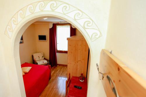 a room with a red bed and an archway at Albergo Adele in Bormio