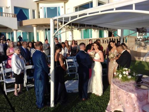 a bride and groom walking down the aisle at a wedding at La Mansión Residency Suites Ensenada in Ensenada