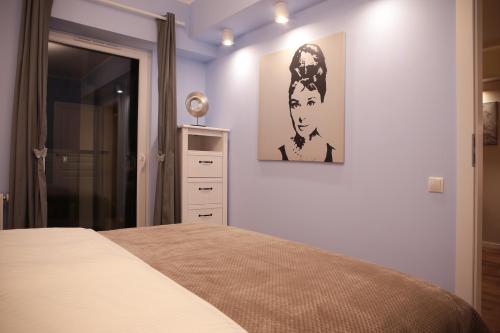 ポズナンにあるSuper-Apartamenty VIP Vintageのベッドルーム1室(ベッド1台付)が備わります。壁に絵が飾られています。