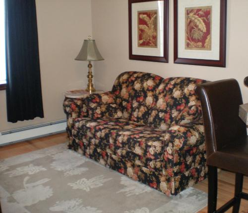 a couch sitting in a living room with a lamp at Spanish Bay Inn, CANADA in Sydney