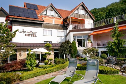 a hotel with solar chairs in front of it at Ringhotel Teutoburger Wald in Tecklenburg