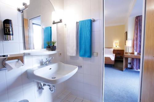 y baño blanco con lavabo y ducha. en Trip Inn Klee am Park Wiesbaden, en Wiesbaden
