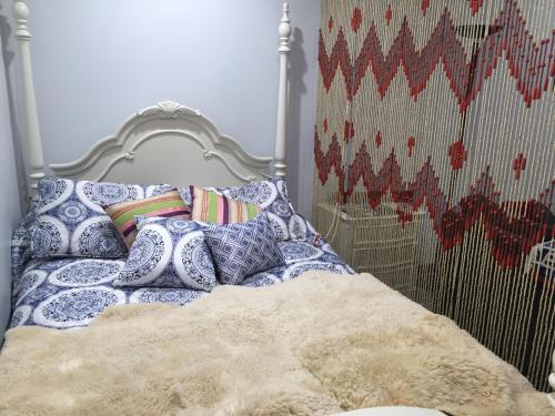 łóżko z niebiesko-białymi poduszkami w obiekcie Eycat Lodging Company Guest House w mieście Wapiti