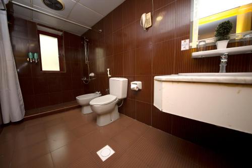 a bathroom with a toilet and a sink at Mount Royal Hotel in Dubai