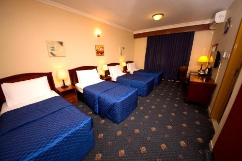 En eller flere senger på et rom på Mount Royal Hotel
