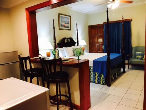 a bedroom with a bed and a table and chairs at Rayon Hotel in Negril