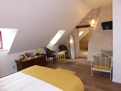 a bedroom with a yellow bed and a living room at La Loubertine in Géanges