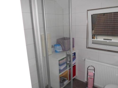 ein kleines Zimmer mit einem Regal und einem Fenster in der Unterkunft Apartment Hinrichs in Bad Zwischenahn