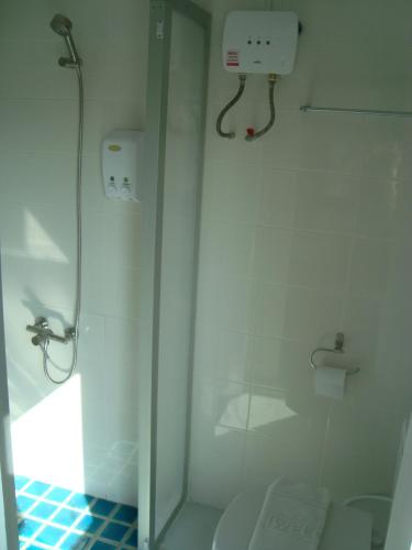 a white bathroom with a shower and a toilet at L42 Hostel Suvarnabhumi Airport in Lat Krabang