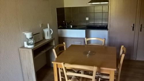 une cuisine avec une table et des chaises dans une pièce dans l'établissement la grange de loghju, à Villefort