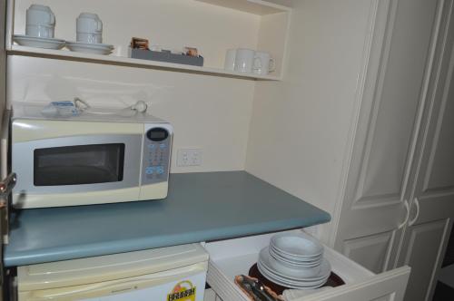 un microondas sentado en un mostrador azul en una cocina en Excelsior Motor Inn, en Port Macquarie