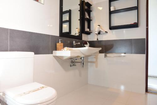 a bathroom with a toilet and a sink and mirrors at Amal Beach Hotel in Bentota