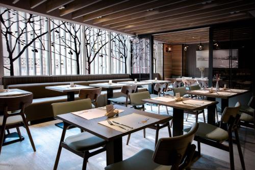 a restaurant with tables and chairs and windows at Changyu Hotel in Tainan