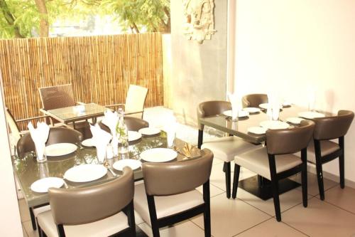 a dining room with a table and chairs and a laptop at Dragonfly Hotel - The Art Hotel in Mumbai
