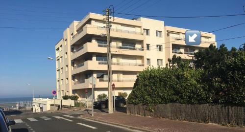 un edificio blanco con un cartel en el costado en La Croix du Sud, en Le Touquet-Paris-Plage