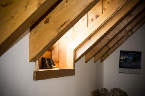 een plank onder de dakrand van een kamer met houten balken bij Albergo Diffuso Zoncolan in Ovaro