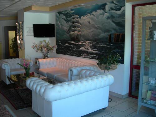 a living room with a couch and a painting at Apart Hotel Norden in Norden