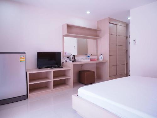 a bedroom with a bed and a television in it at Baan mek mok in Bangkok
