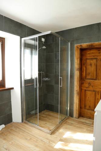 a shower with a glass door in a room at Cjase da Maestre in Raveo