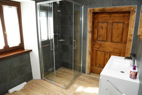 a bathroom with a shower with a glass door at Cjase da Maestre in Raveo