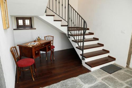 a room with a desk and a staircase with a table at Cjase da Maestre in Raveo