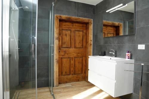 a bathroom with a shower and a sink and a mirror at Cjase da Maestre in Raveo