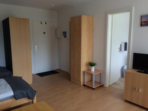 - une chambre avec un lit, une télévision et une porte dans l'établissement Ferienwohnung "Krabbe", à Bremerhaven