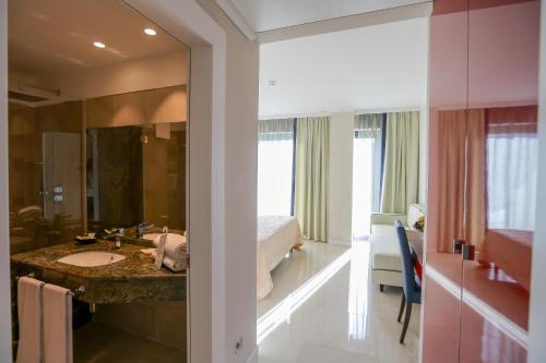 a bathroom with a sink and a bed in a room at Victoria Palace Cefalù in Cefalù