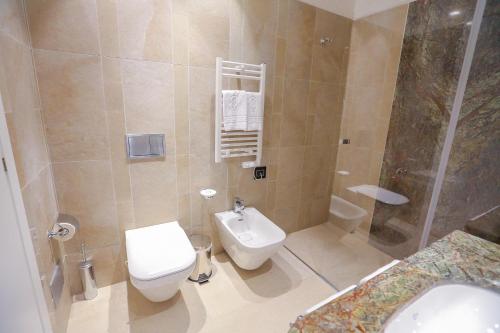 a bathroom with a toilet and a sink and a shower at Victoria Palace Cefalù in Cefalù