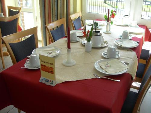 einen Tisch mit einem roten und weißen Tischtuch drauf in der Unterkunft Apart Hotel Norden in Norden