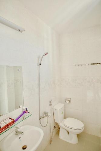 a white bathroom with a toilet and a sink at Phu Hong Hotel in Phu Quoc