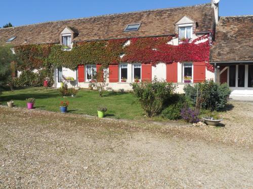 a house covered in ivy with plants on it at Ferme les Rousseaux in La Belliole
