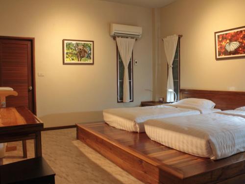 1 dormitorio con 2 camas sobre una mesa de madera en Baan Maka Nature Lodge en Kaeng Kachan