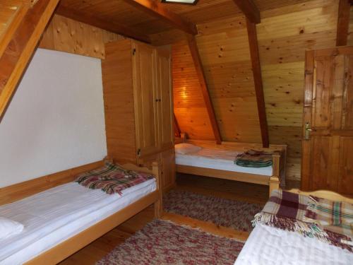 a room with two beds in a wooden cabin at Holiday Home Vile Calimero in Žabljak